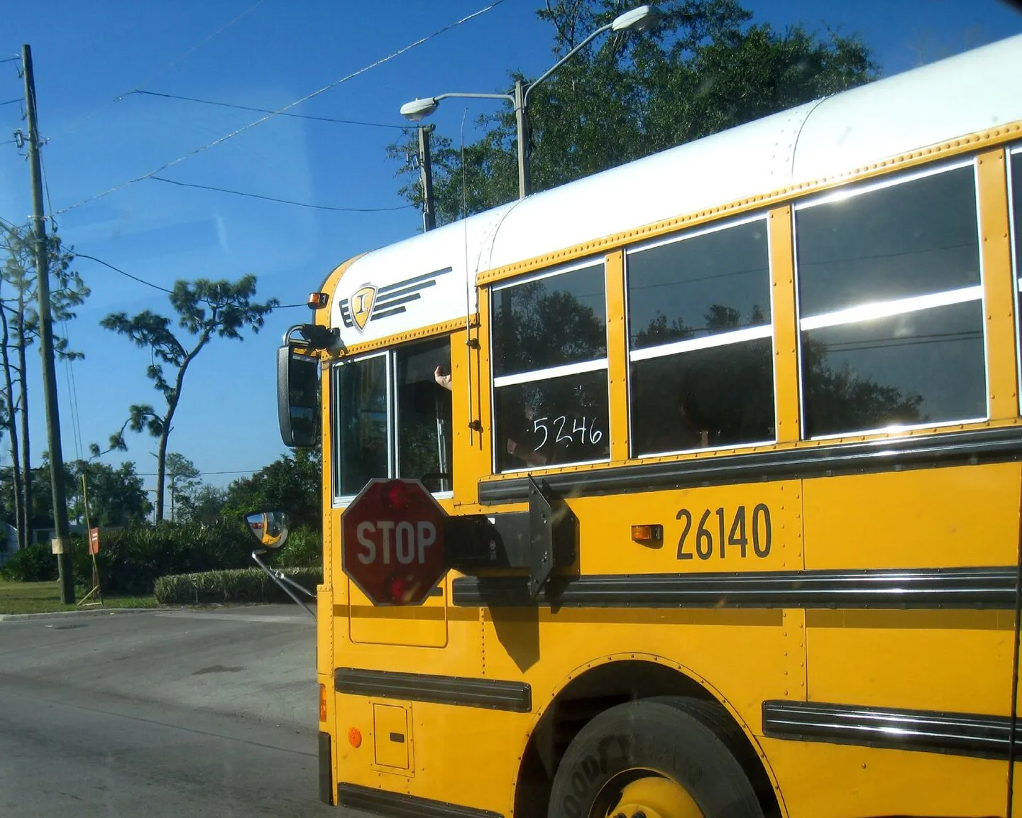 A school bus with its stop arm out at the roadside